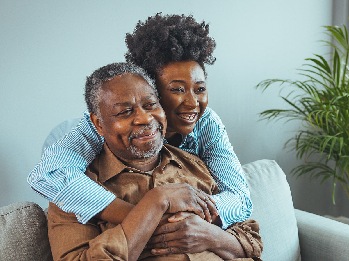 African American husband and wife embrace on the couch