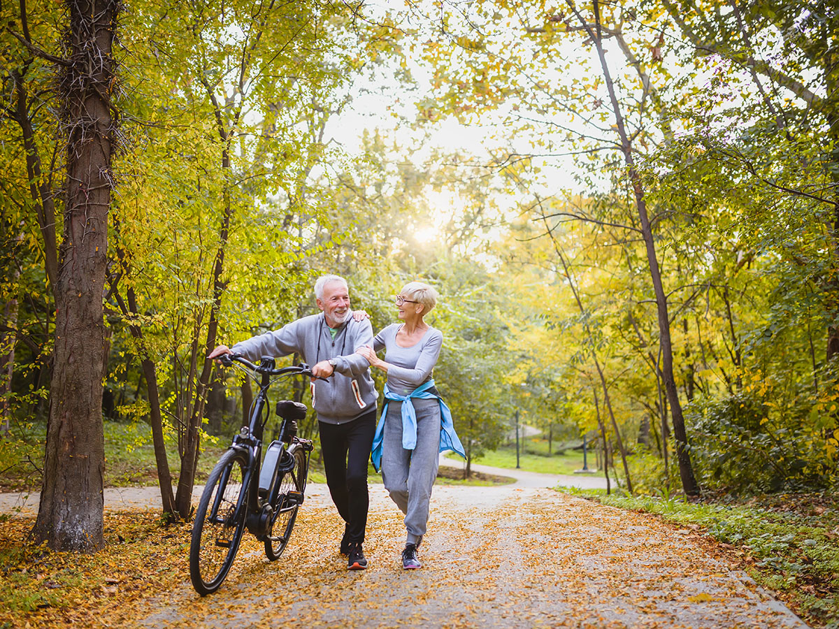 Senior adult couple walking on path in a park