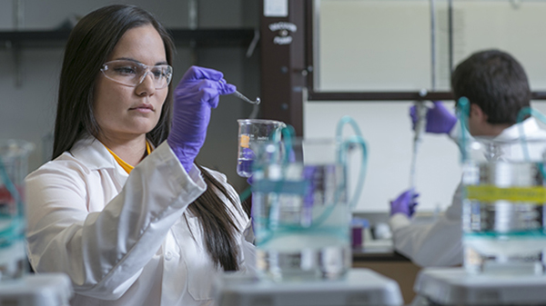 Adult woman wearing goggles works in a laboratory