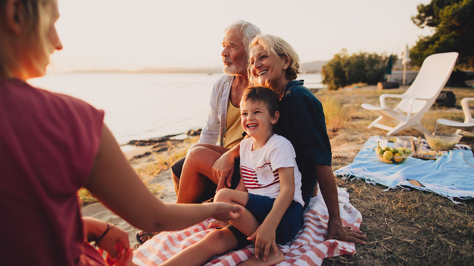 Grandmother enjoying time on the beach with her grandson and family