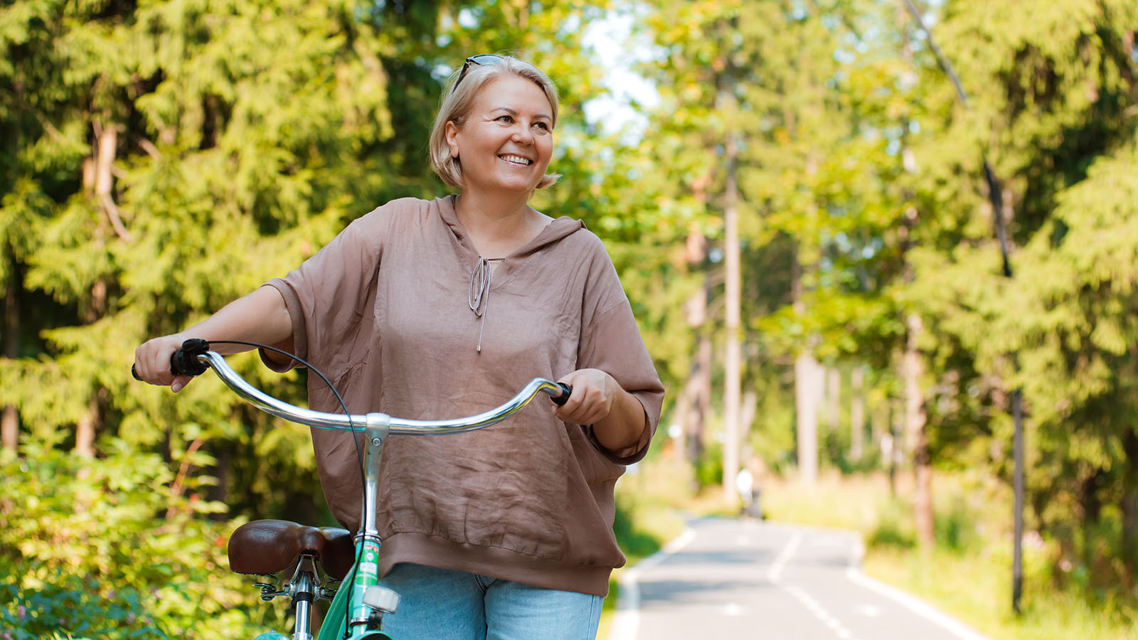 Middle aged woman riding her bike in the woods