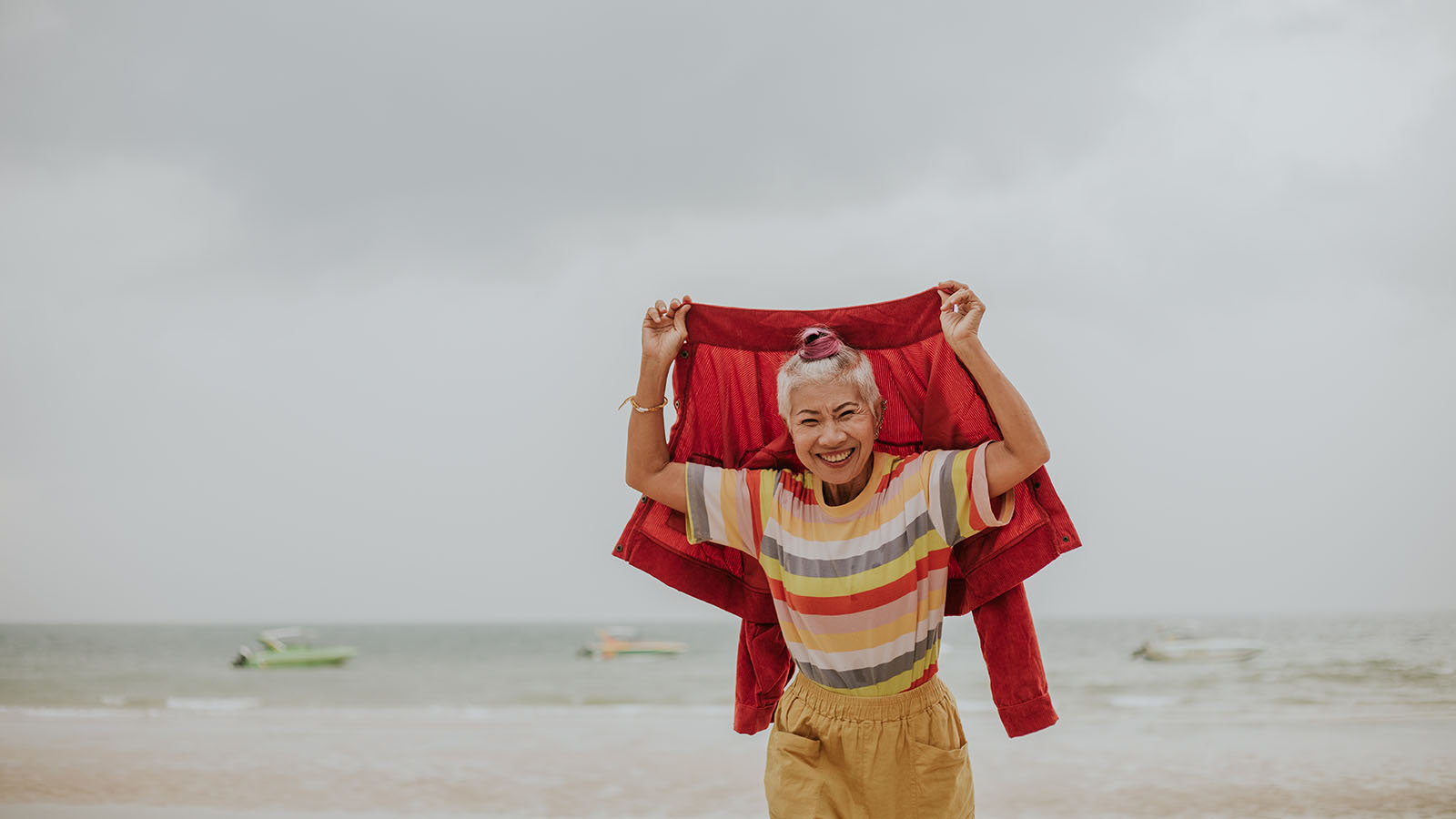 Older woman enjoying the beach on a cloudy day
