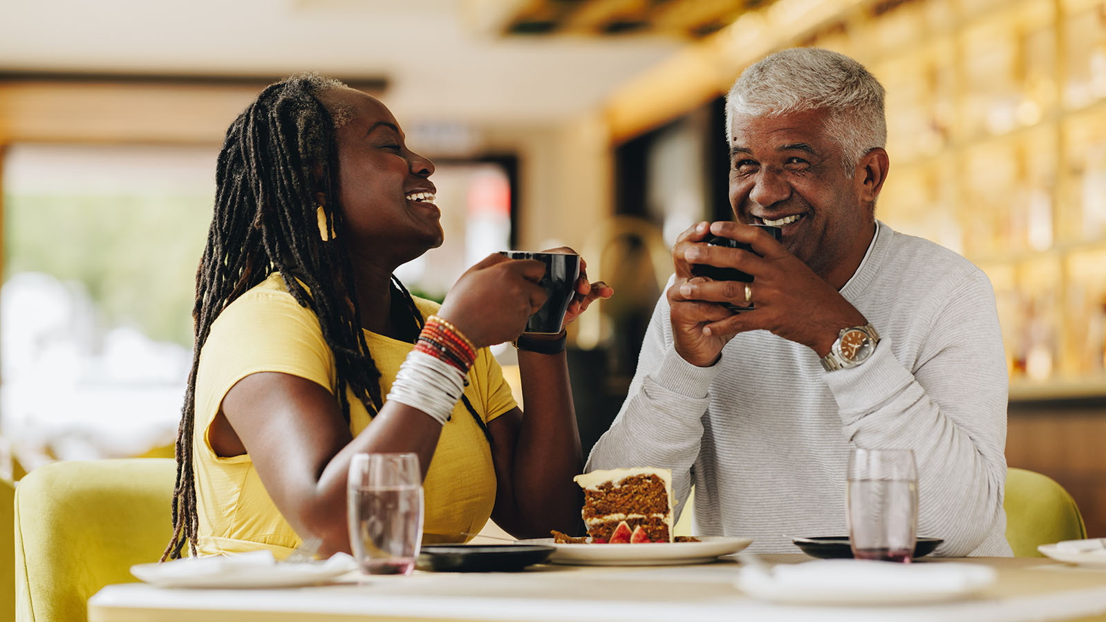 Senior couple enjoying coffee and sharing dessert