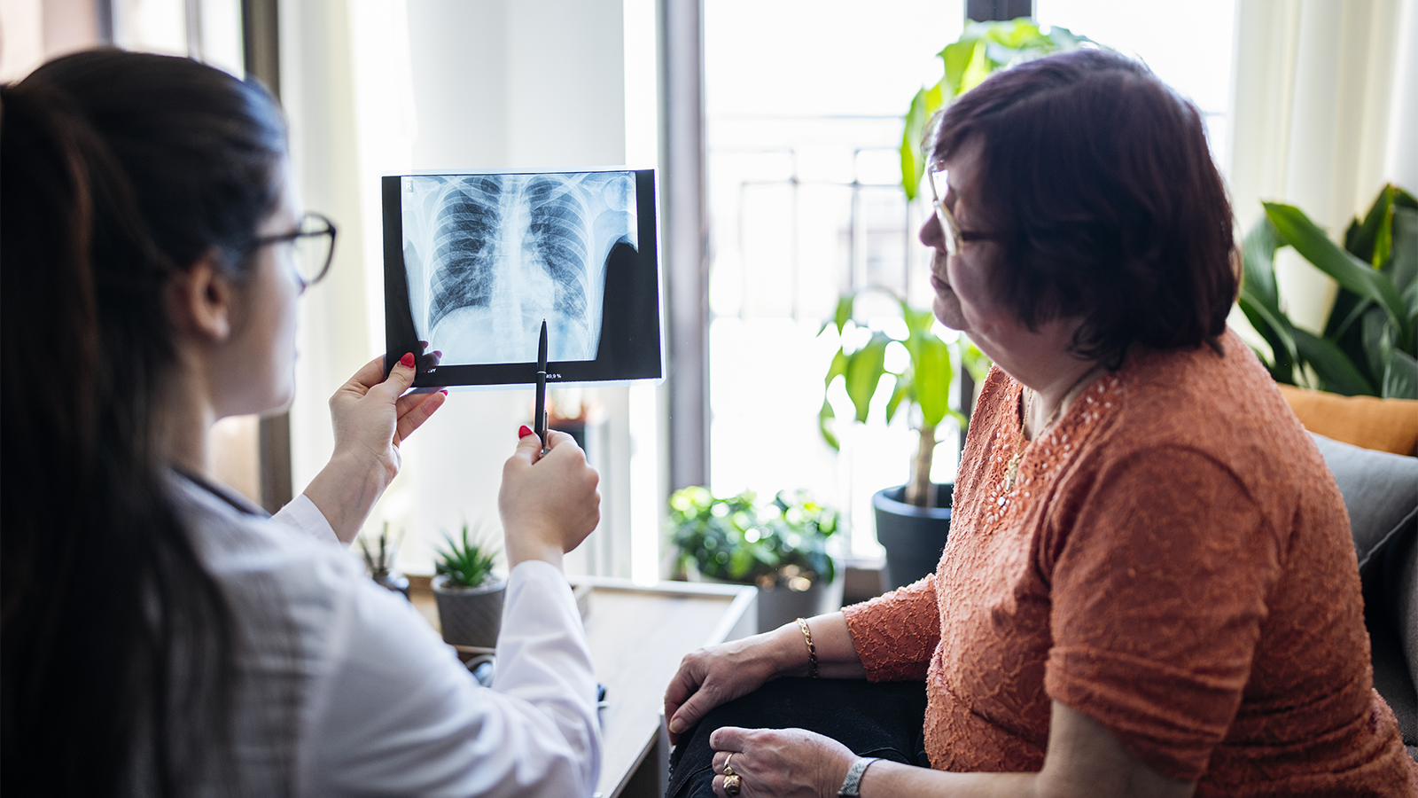 An older female patient and a younger doctor looking at an Xray of her lungs
