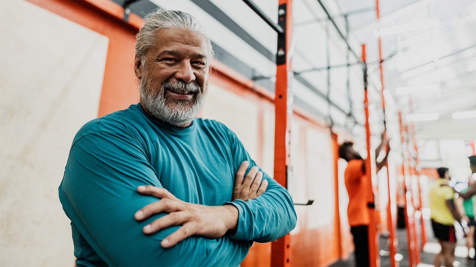 middle aged man taking a break from lifting weights at the gym