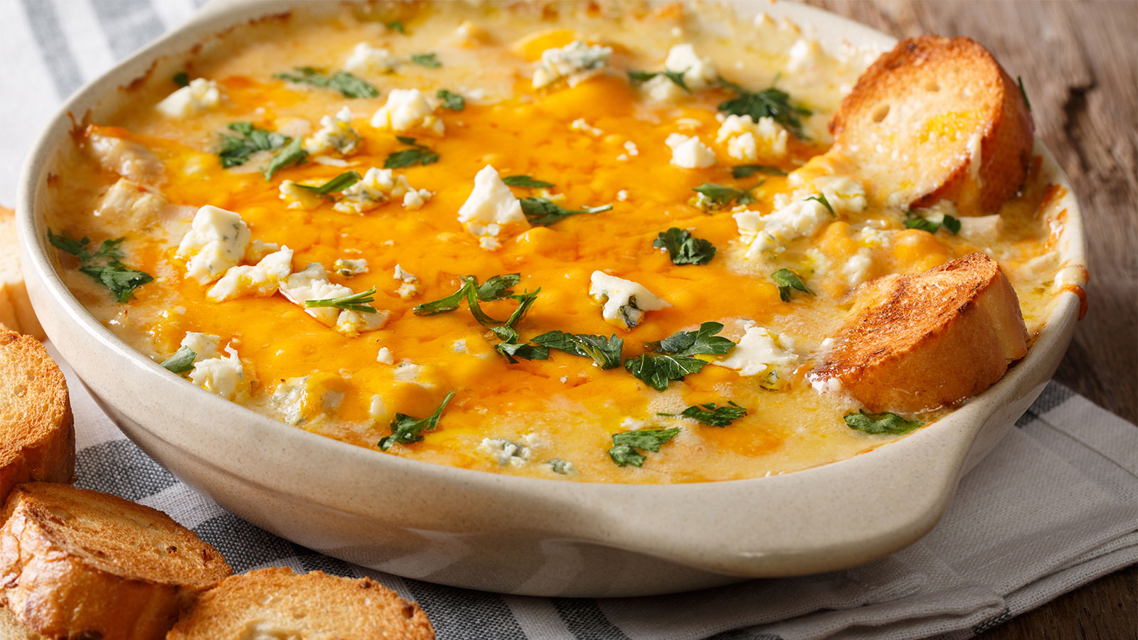 a serving dish of buffalo chicken dip with toasted bread
