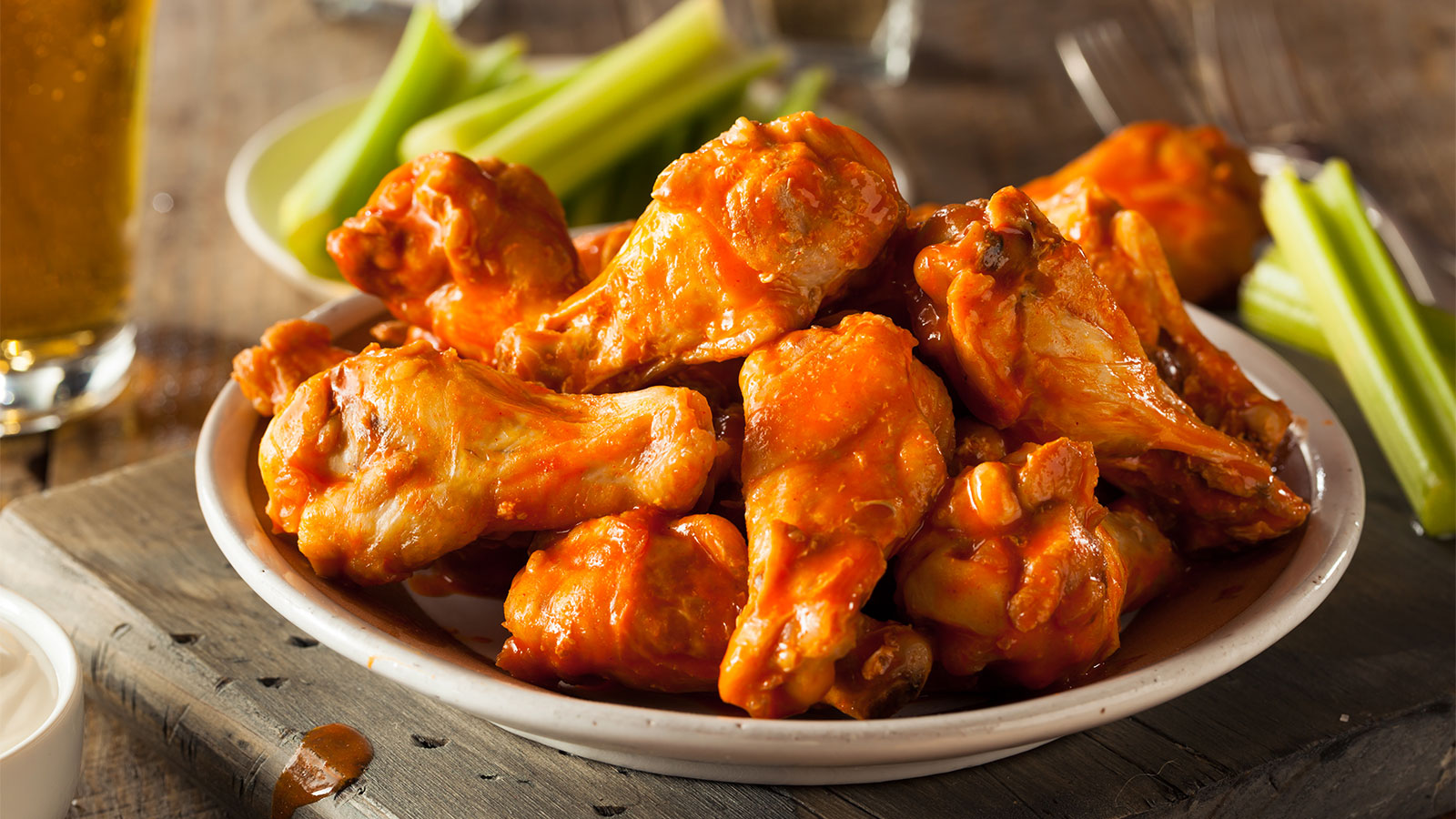 a plate of buffalo wings and celery sticks
