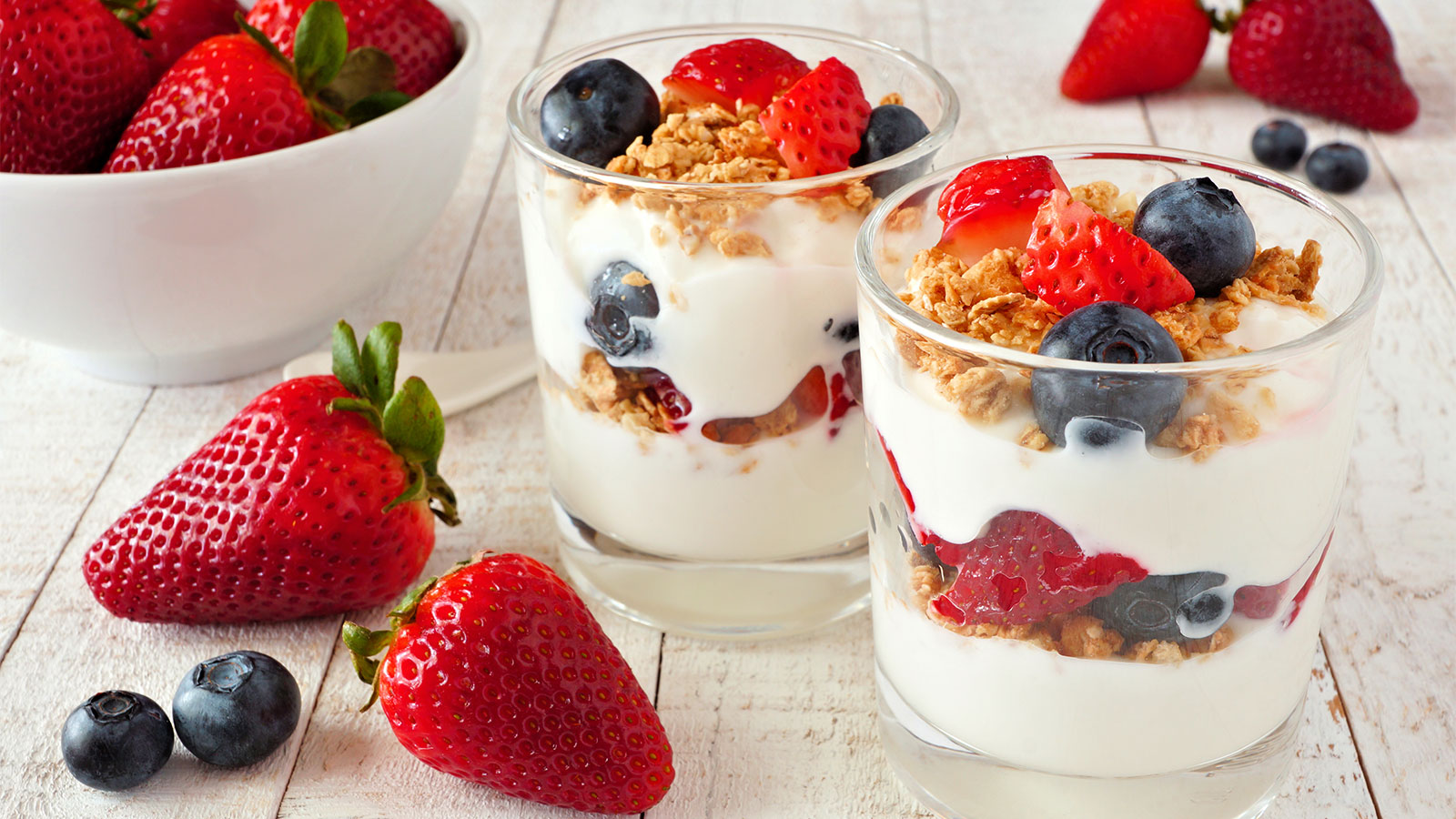 two layered yogurt and fruit parfaits in glasses