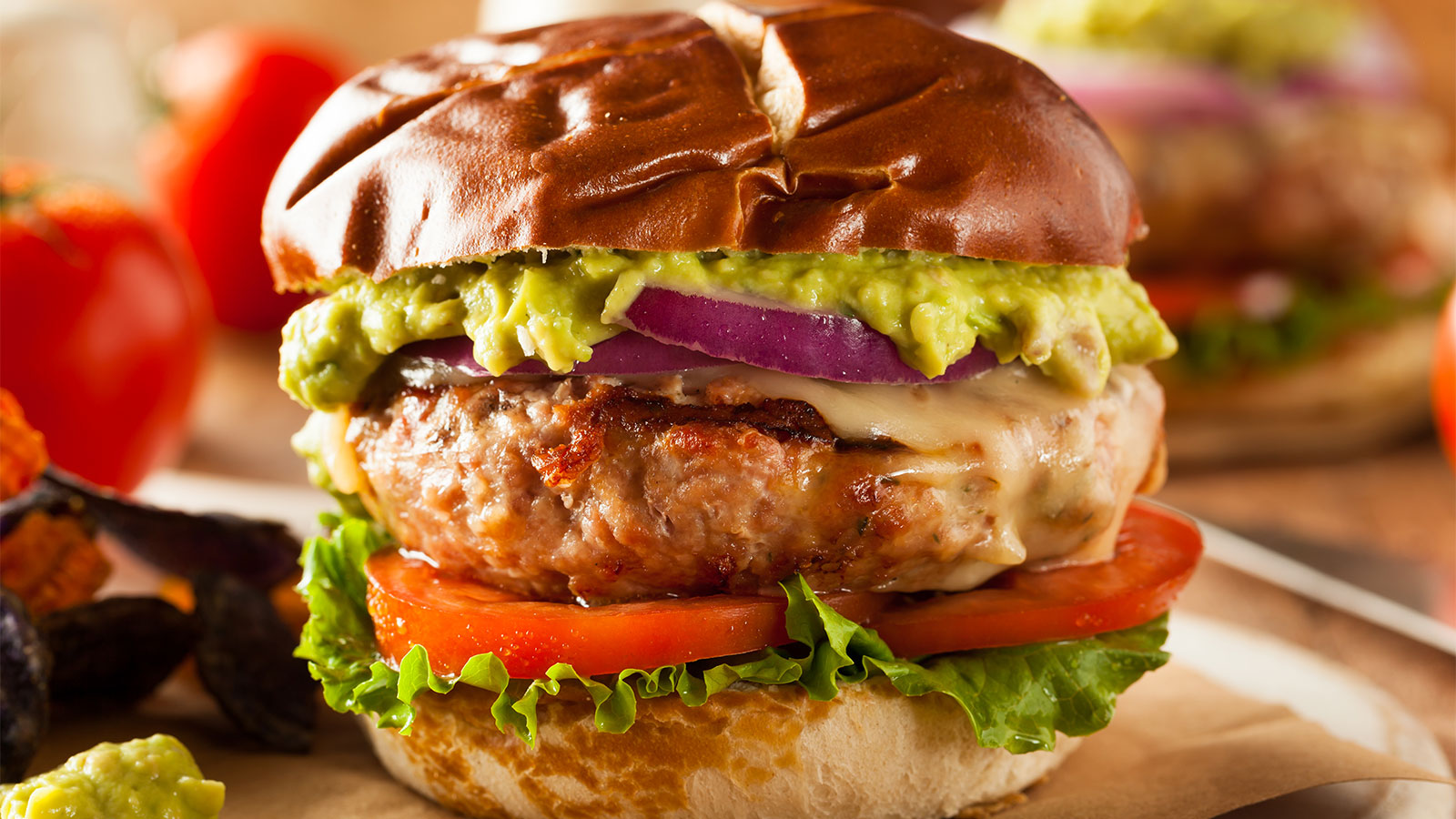 a turkey burger on a bun with lettuce and tomato