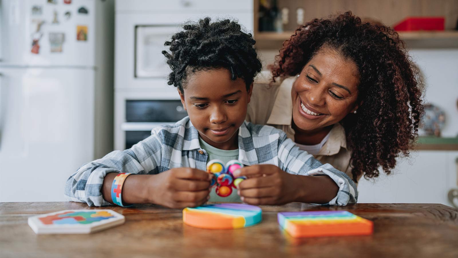 mother and son playing with a toy together at the kitchen table