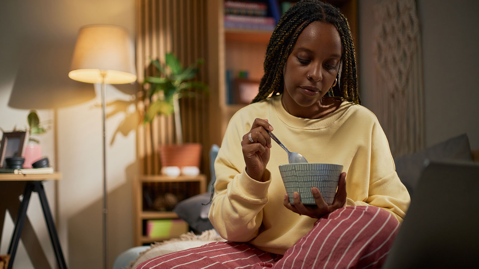 woman holding spoon and bowl and sitting in chair