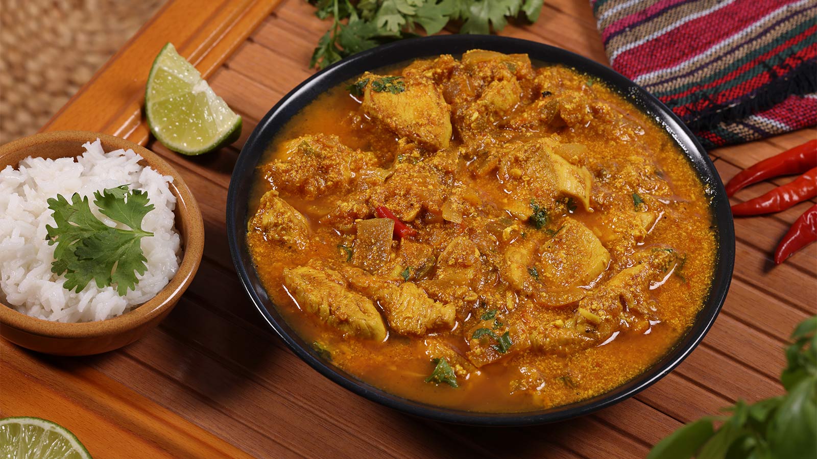 bowl of turmeric chicken next to a bowl of white rice