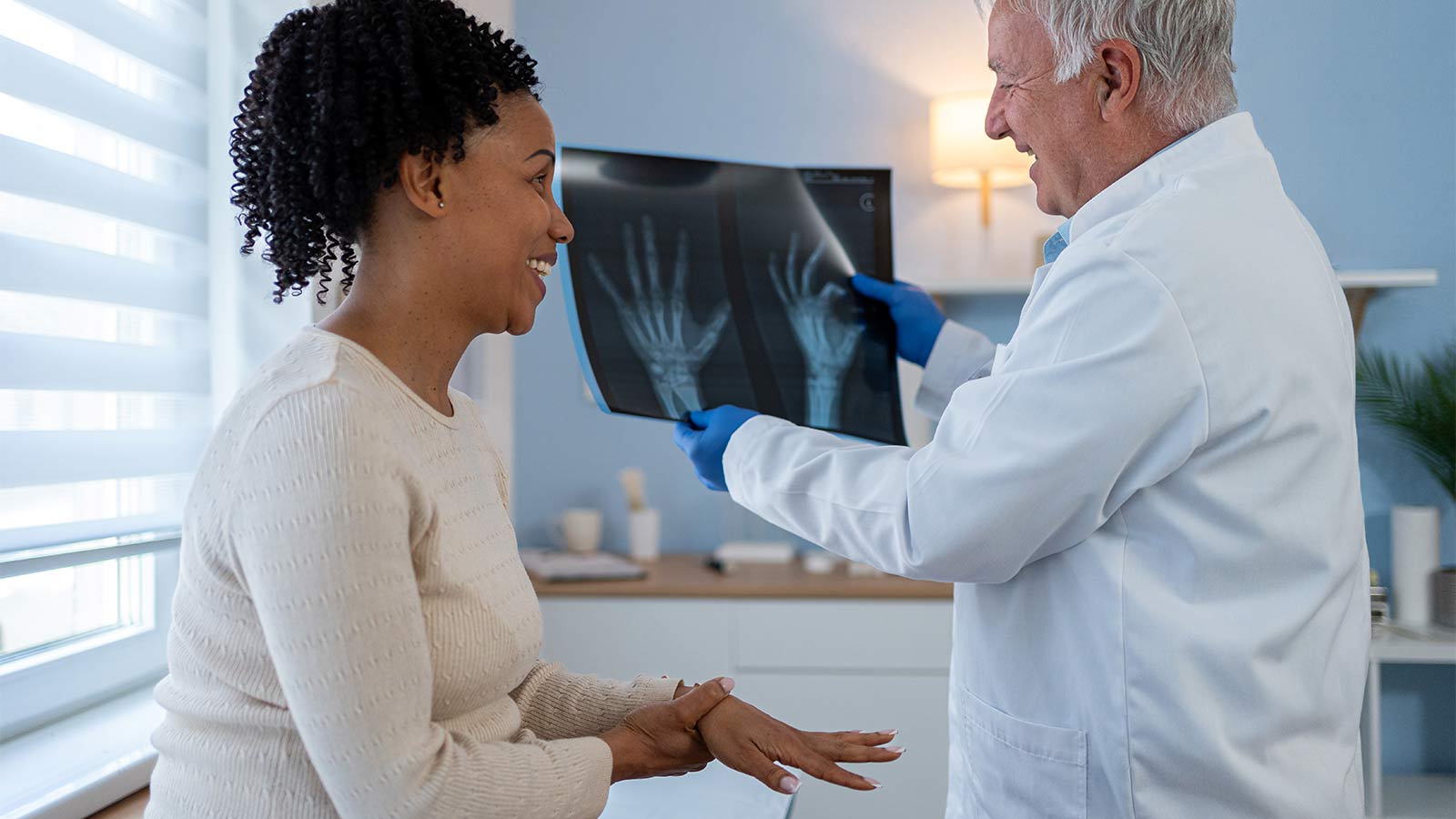 woman looking at x-rays of her hands with her doctor