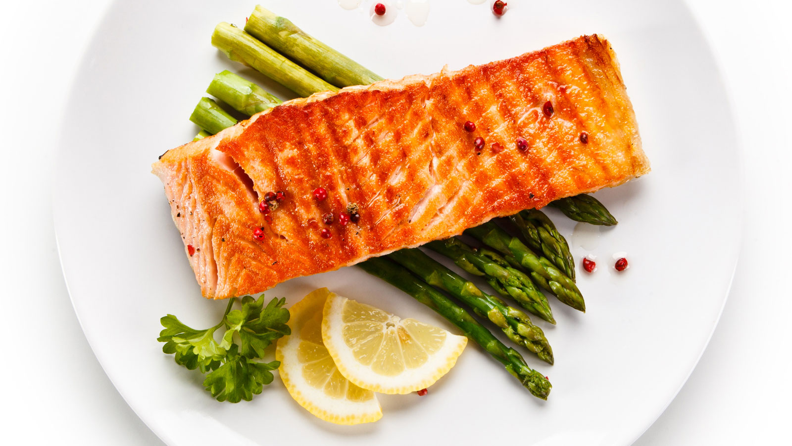 salmon and roasted asparagus on a plate with lemon slice