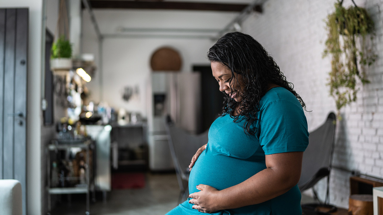 contemplative pregnant woman spending time at home