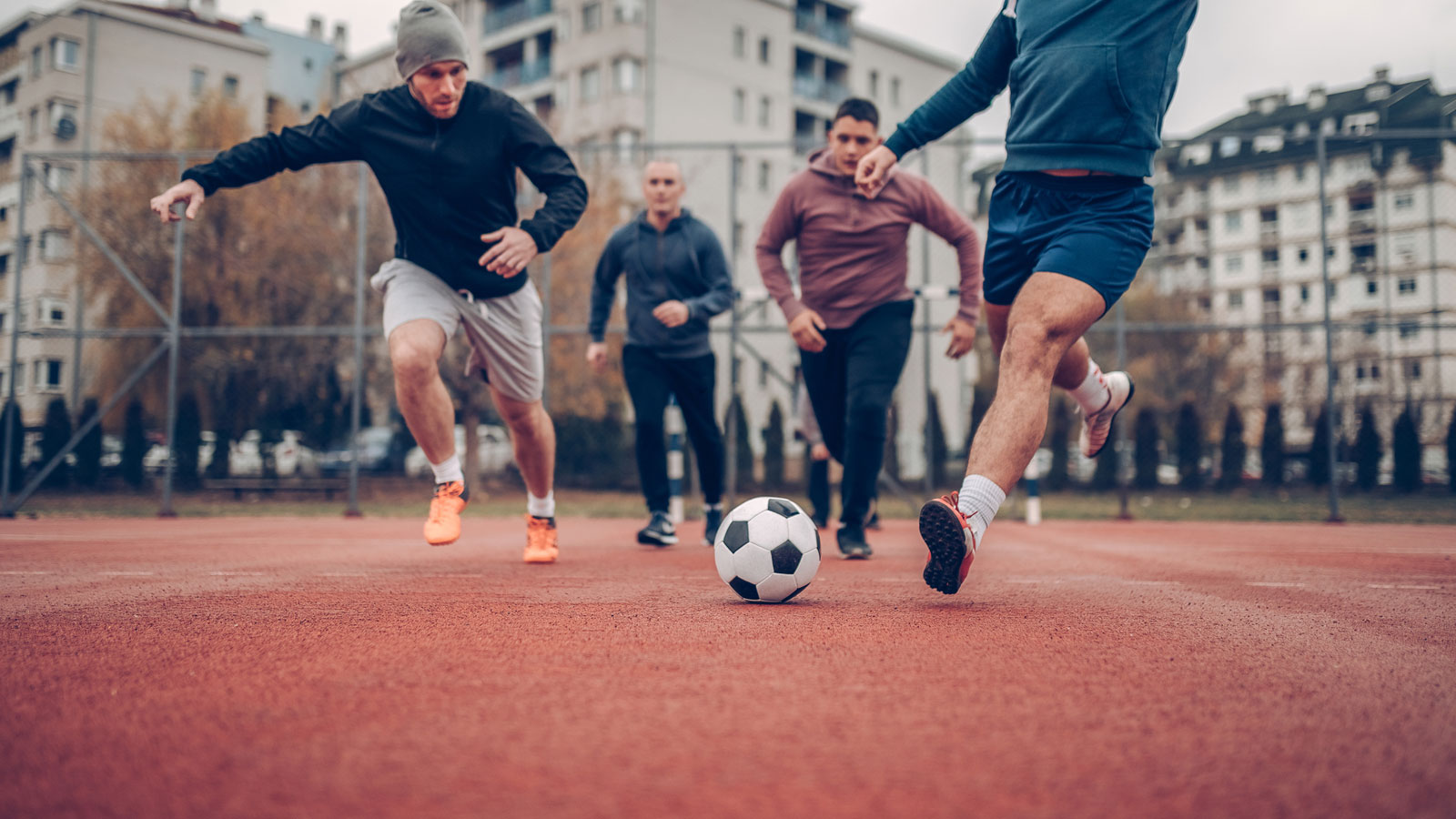 group of men playing soccer in the park