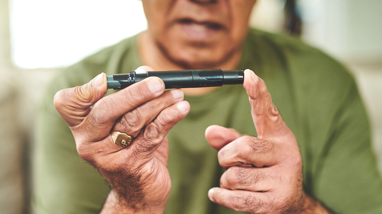 man using a glucose monitor to check his blood sugar