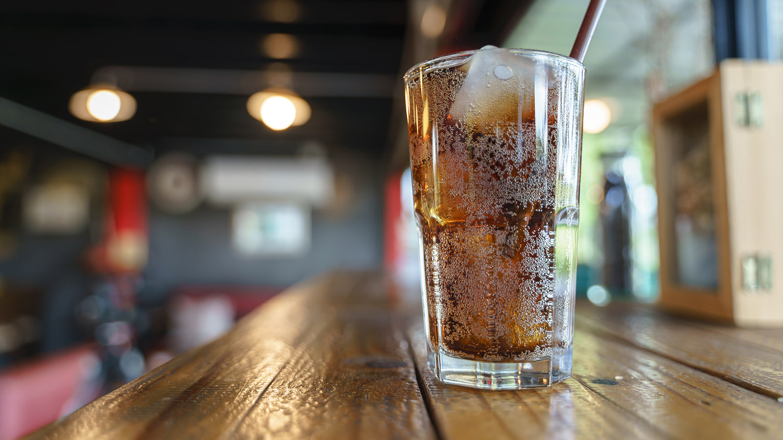 glass of soda with ice on a bar top