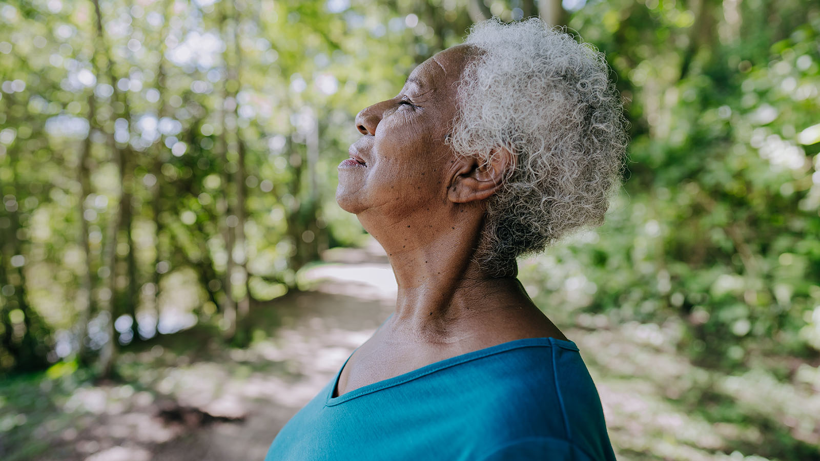 Senior woman in the woods enjoying the fresh air