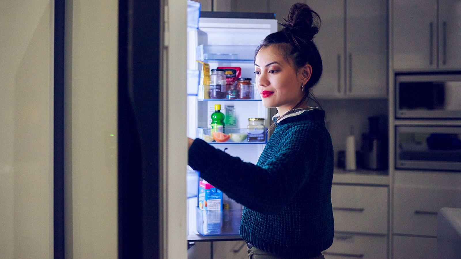Woman looking in her fridge for a midnight snack