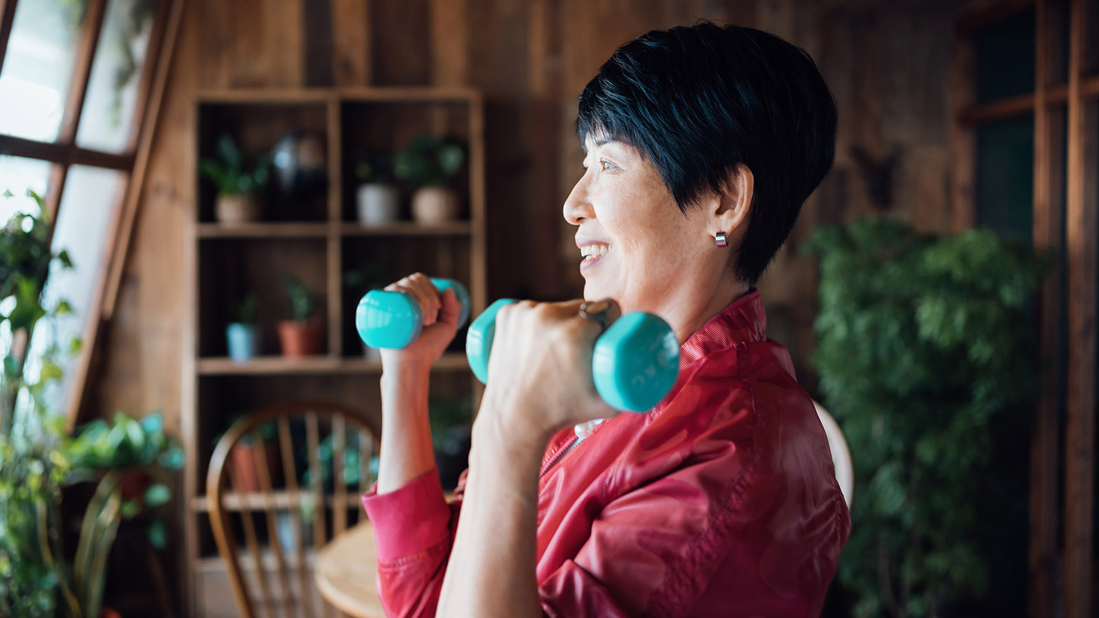 senior woman exercising with hand weights at home