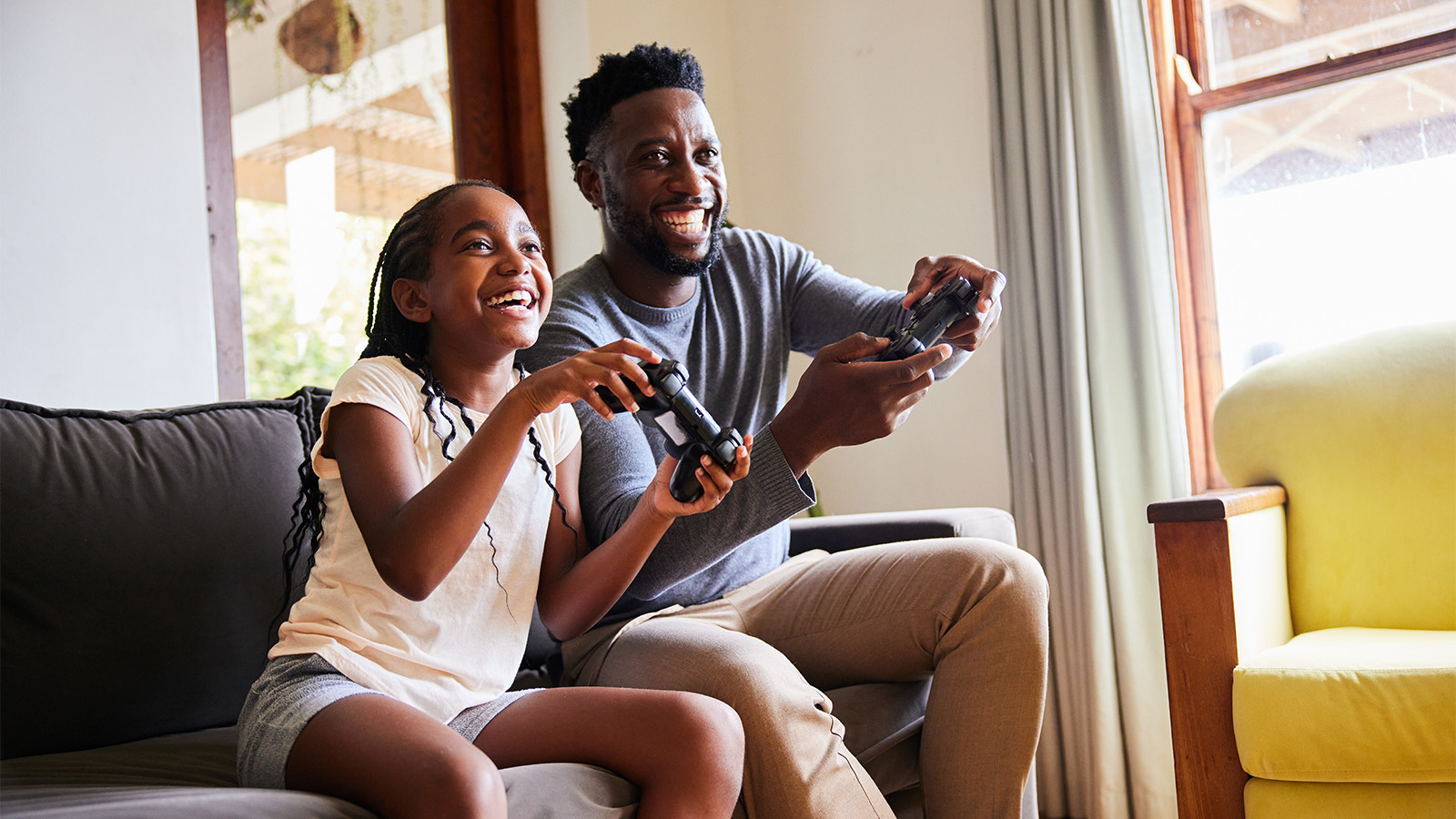 A young brother and sister smiling and active while playing video games