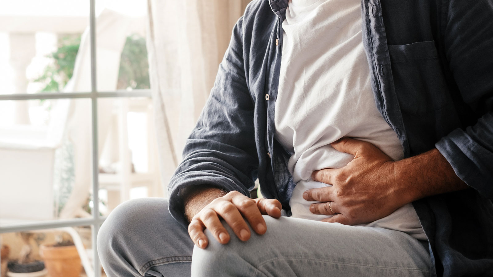 man clutching his stomach in pain