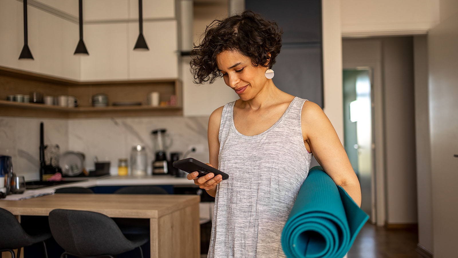 woman booking an appointment on her phone on her way to a yoga class