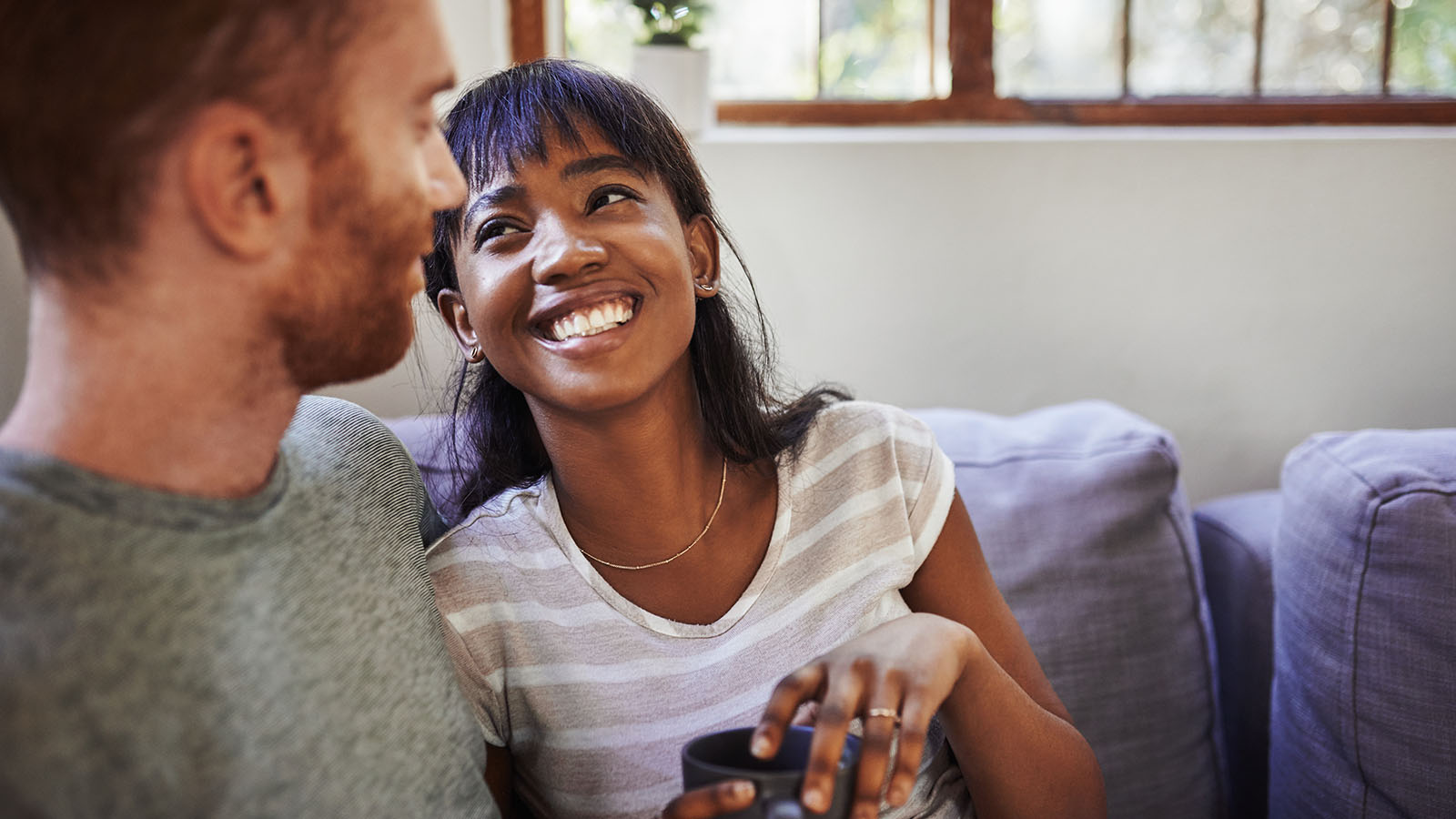 young couple enjoying coffee together on the couch