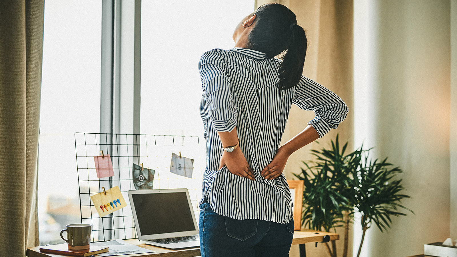 woman holding her lower back in pain