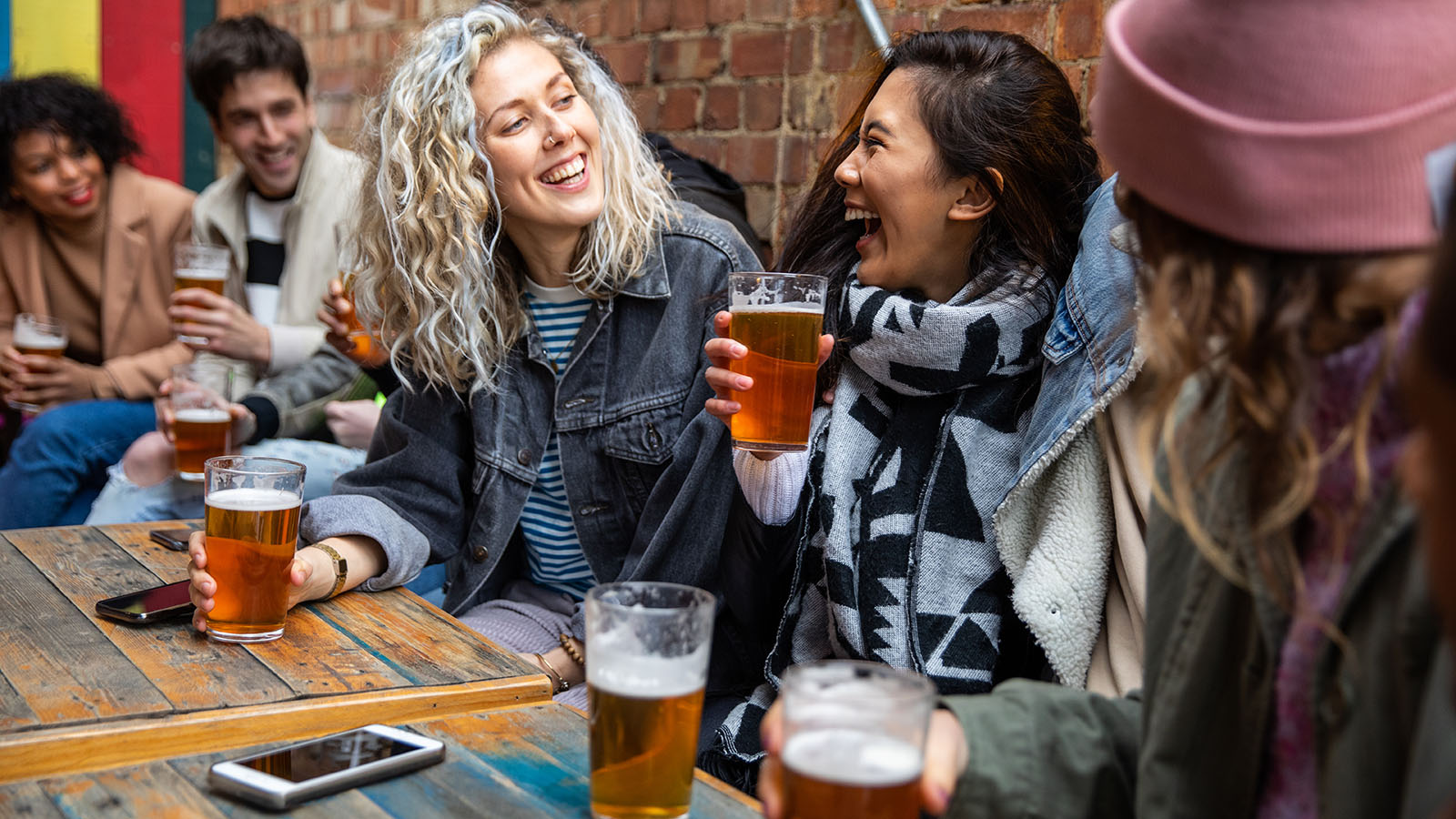 Group of young friends drinking beer together outside