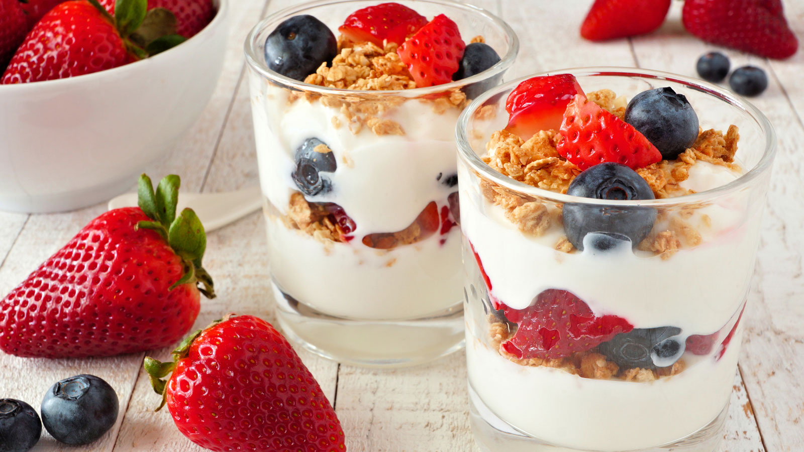 two yogurt parfaits with granola and berries