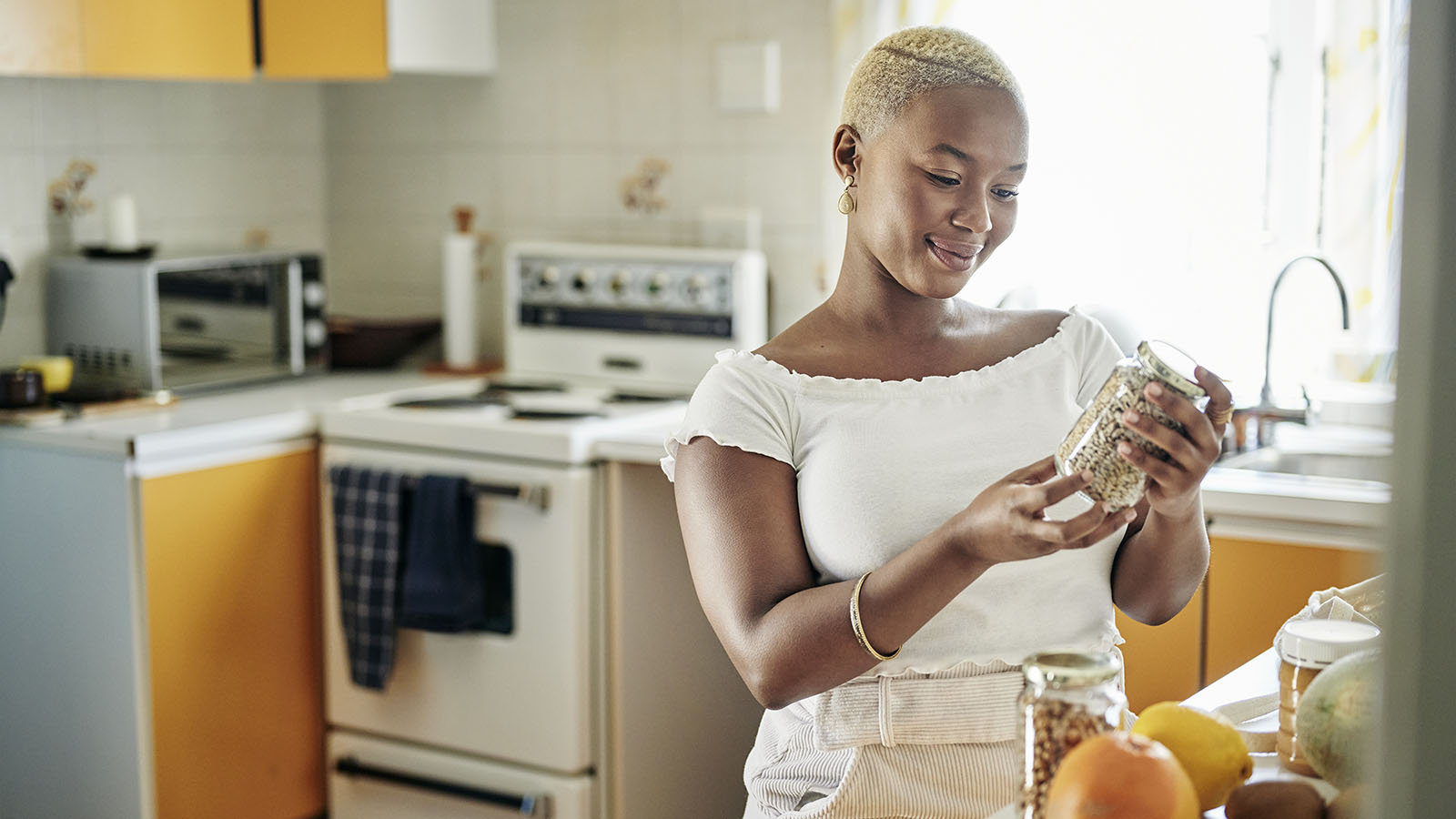 young woman unpacking groceries at home