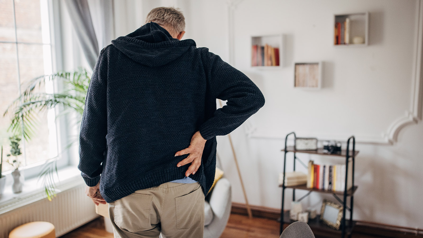 Senior man holding his lower back in pain