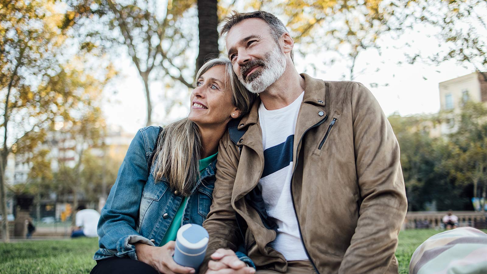 middle aged couple smiling and sitting in the park