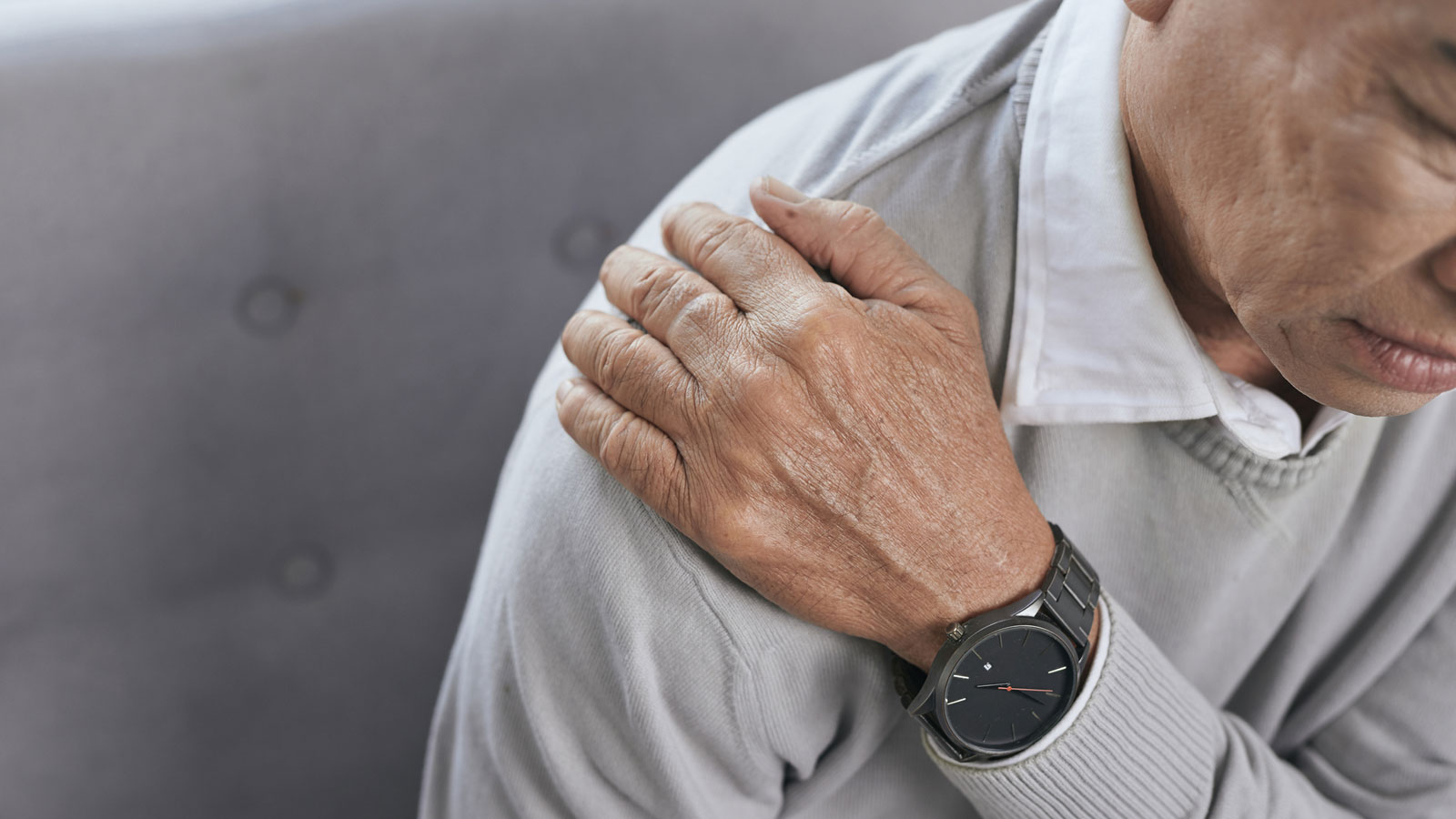 senior man holding his shoulder in pain