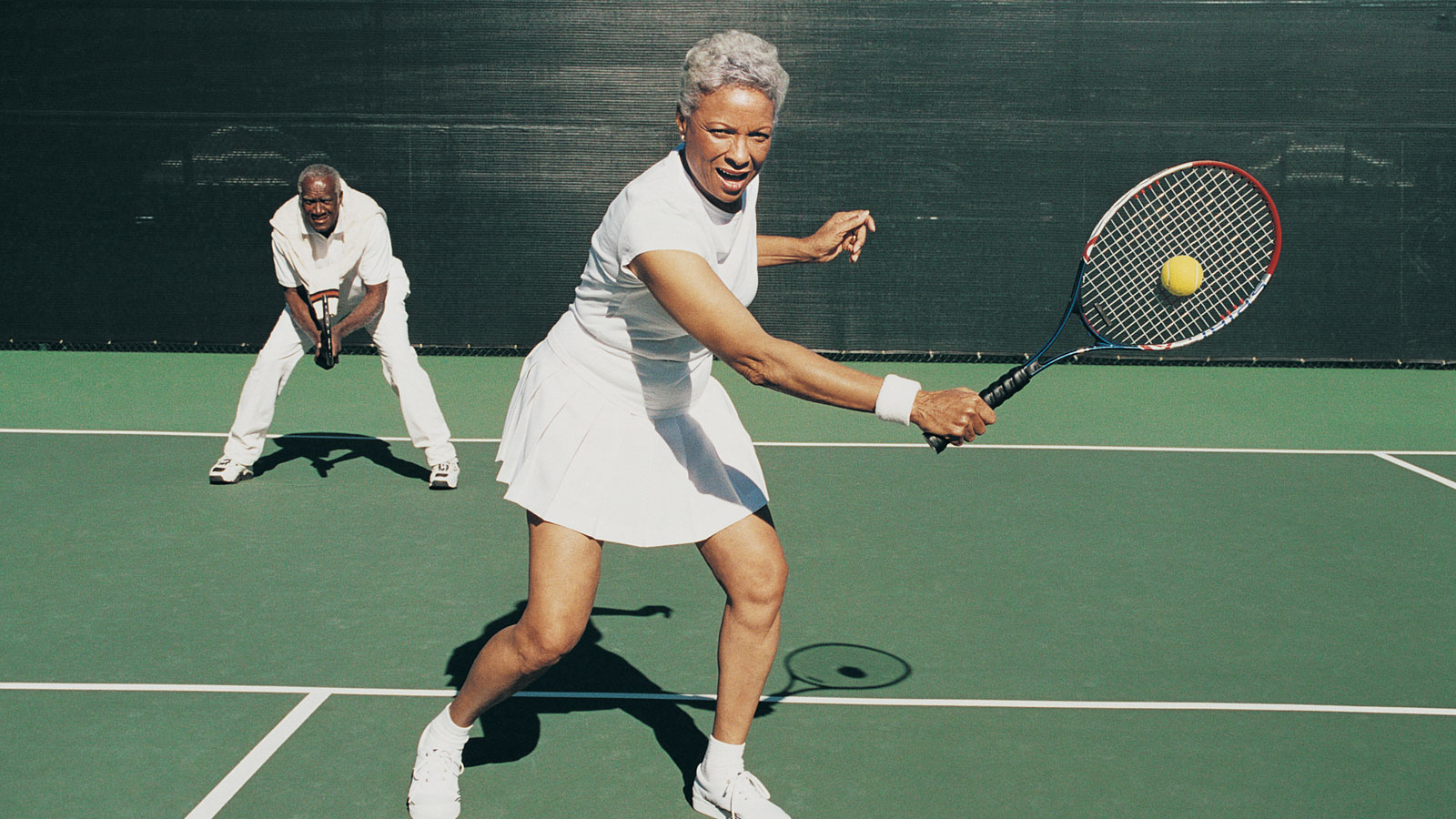 middle aged woman playing tennis