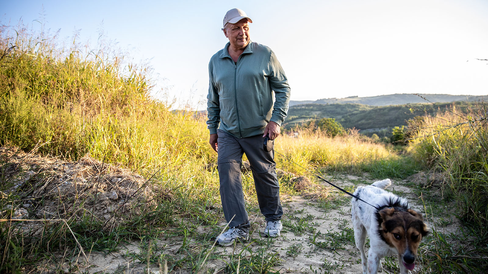 Senior man walking his dog near the beach