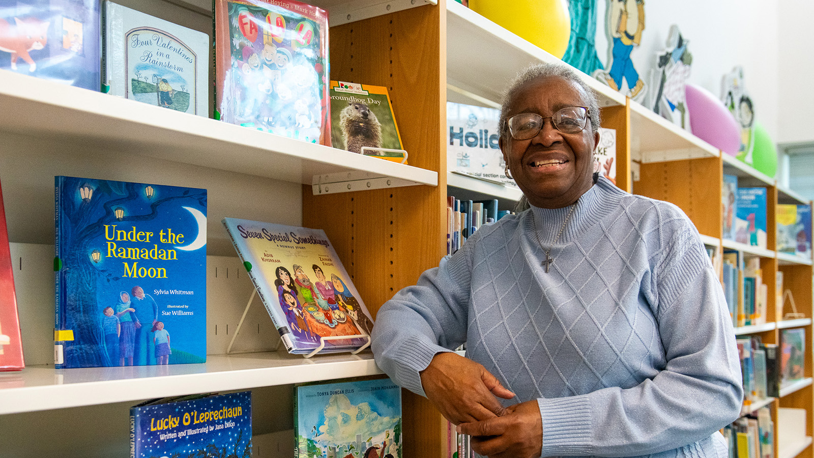 Older woman posing and smiling in a library
