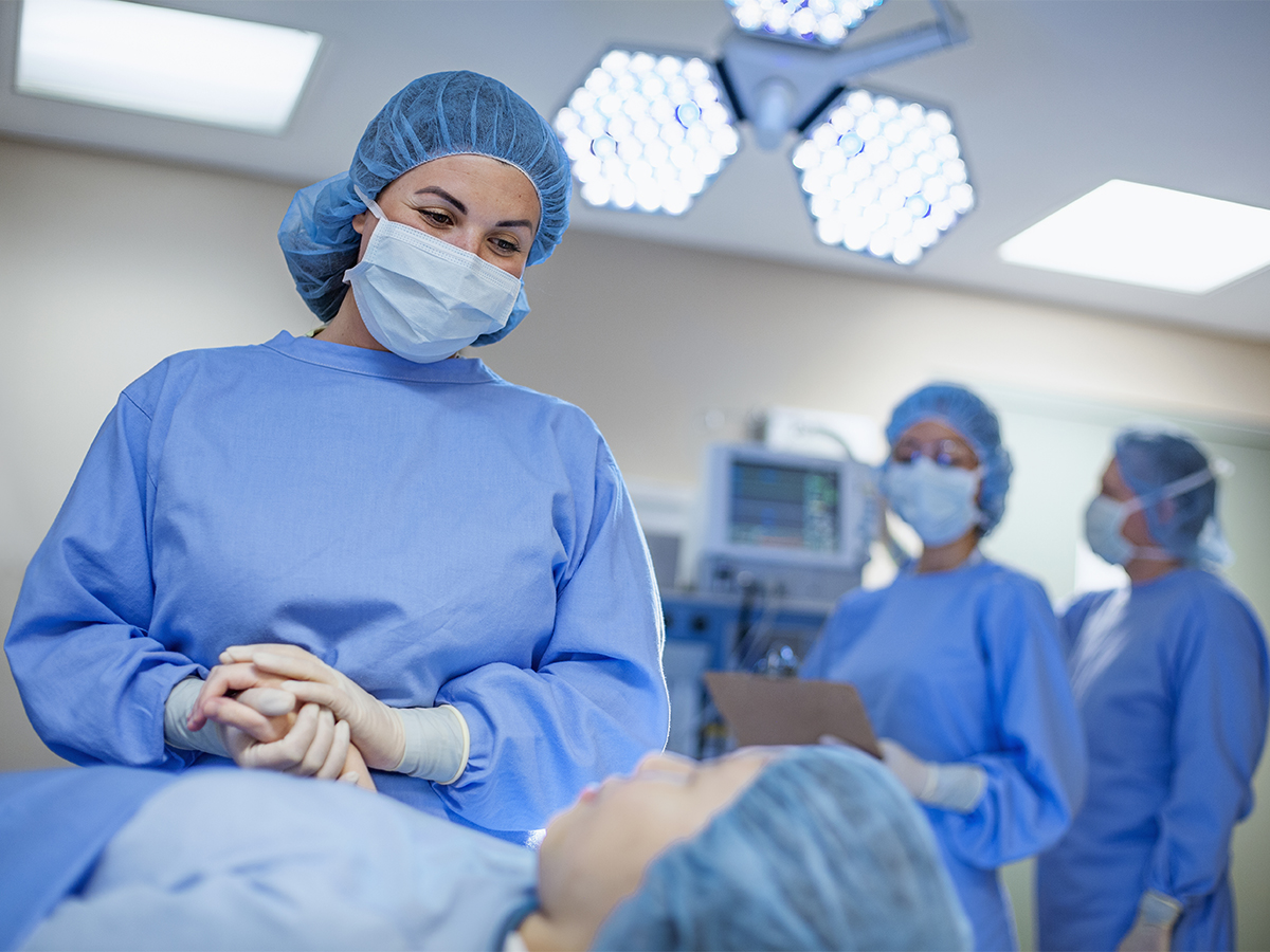 Surgeon smiling and holding patient's hand