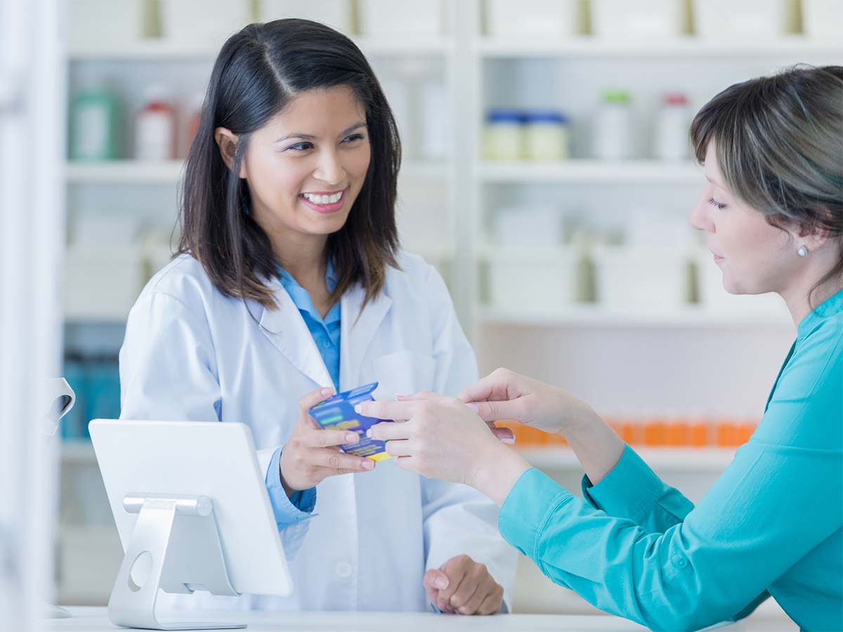 Pharmacist smiling and sharing information with patient