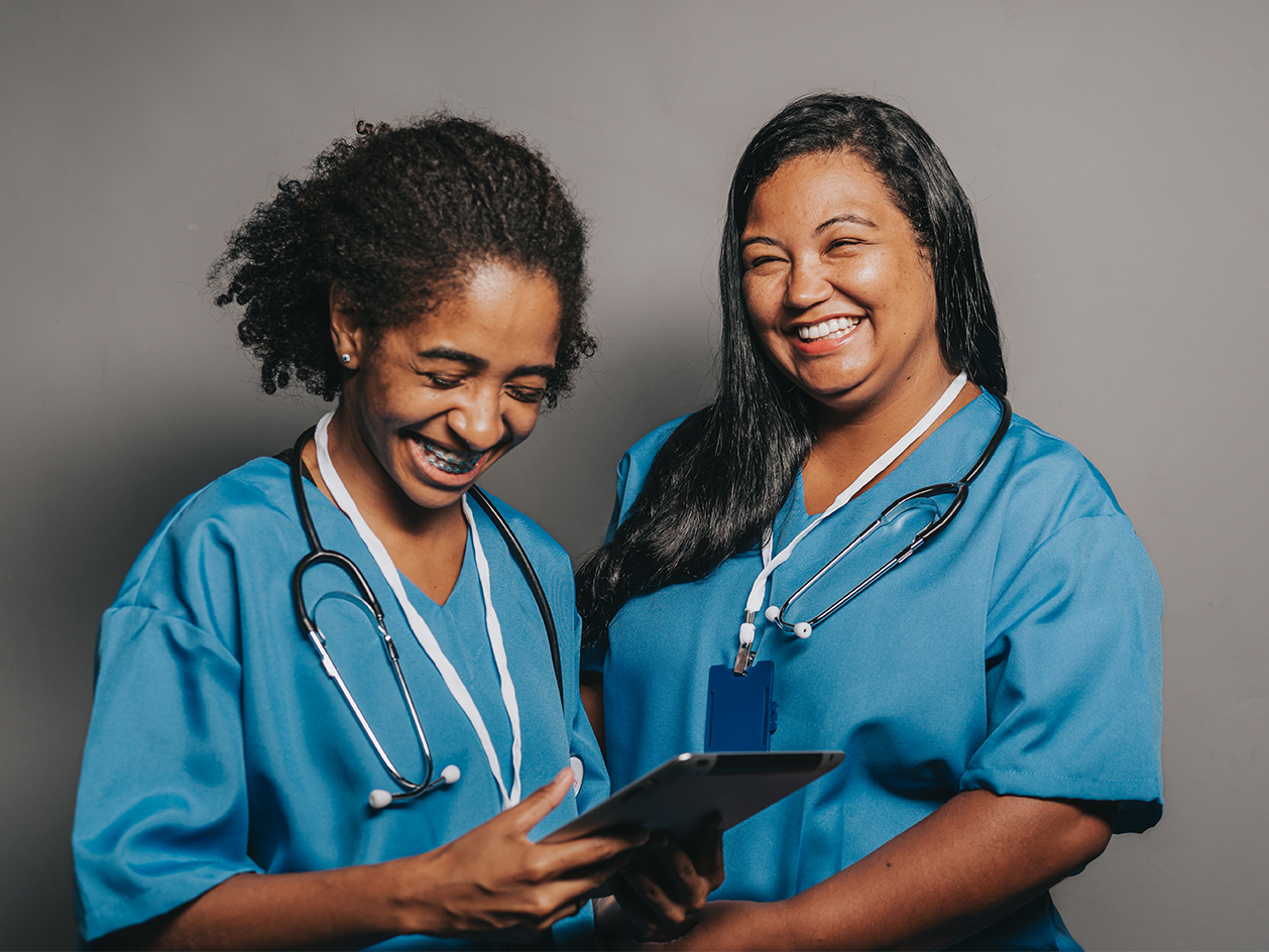 Two female medical professionals talking and laughing