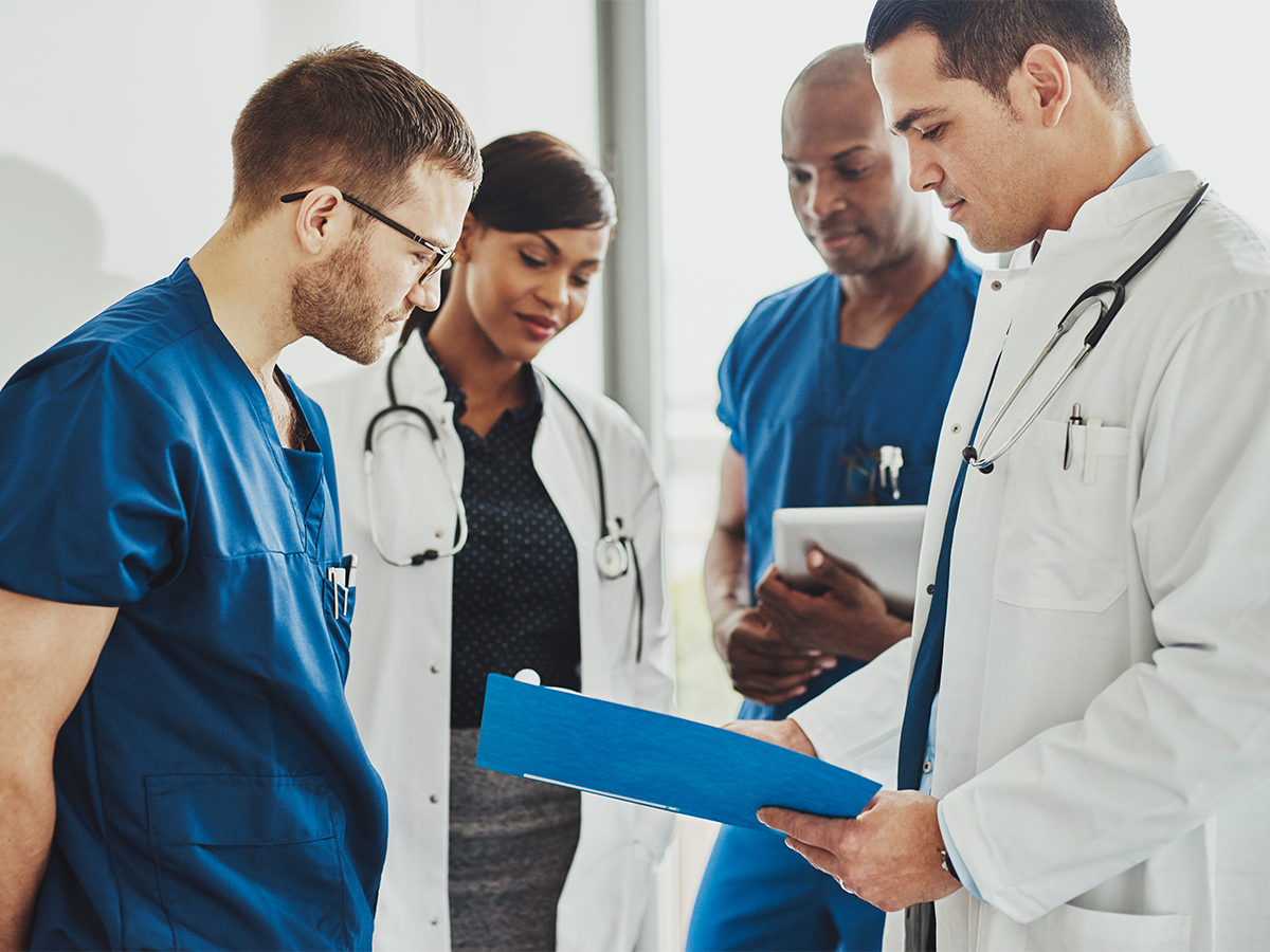 Group of male and female doctors discussing a chart