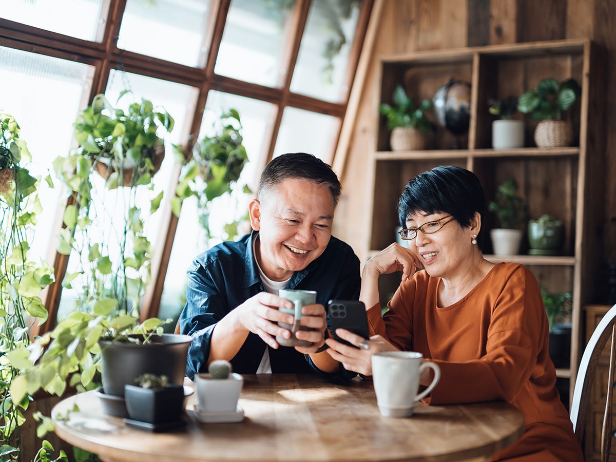 An adult couple sits at the dining room table enjoying coffee