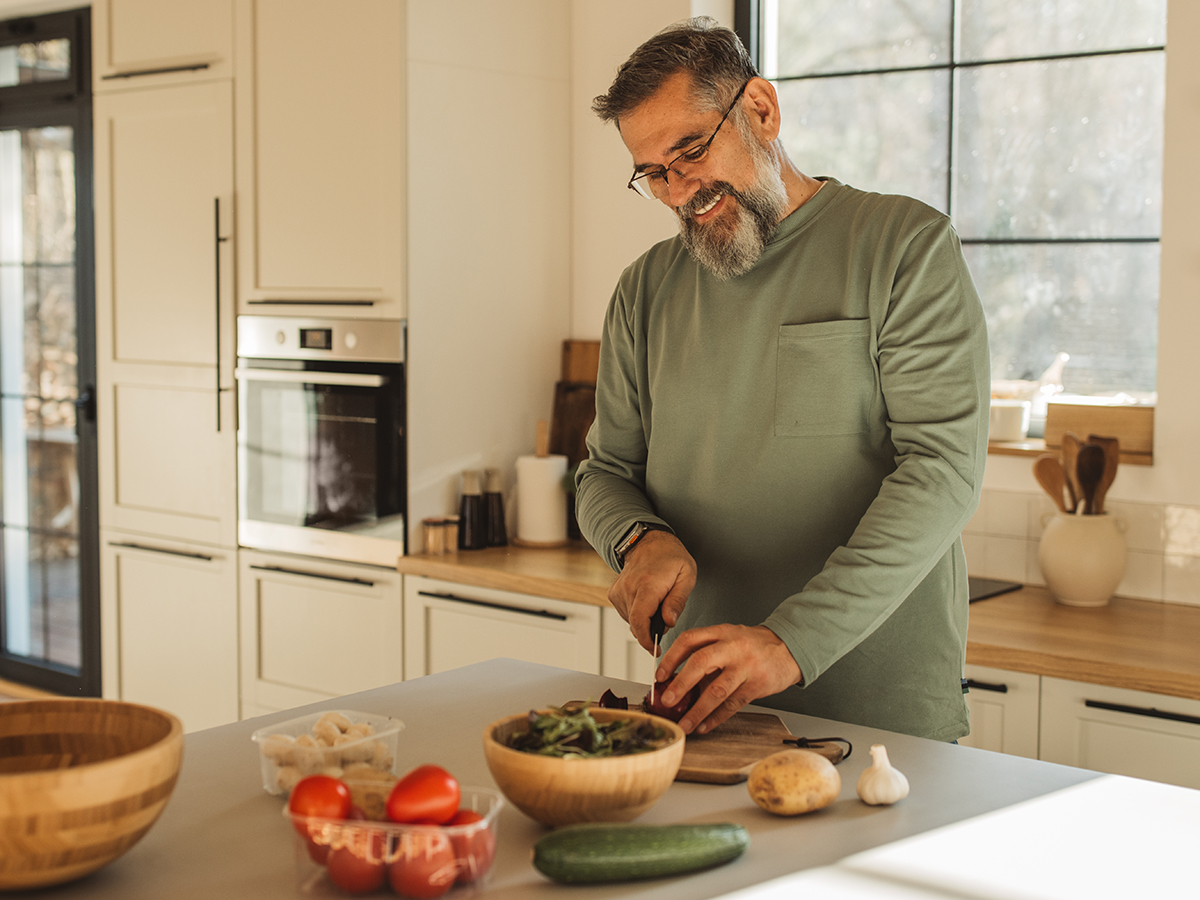 Adult male cutting vegetables in the kitchen