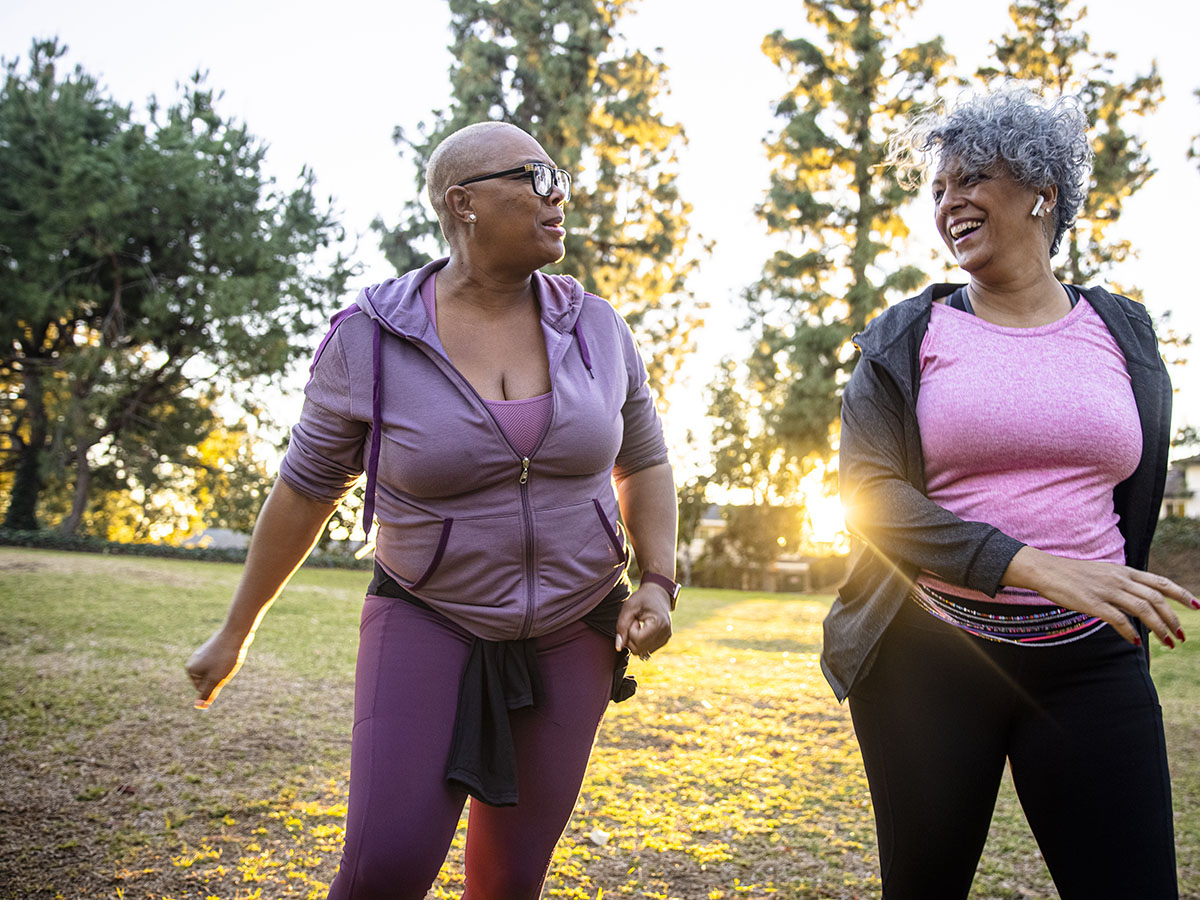 Two mature black woman walking together in nature.