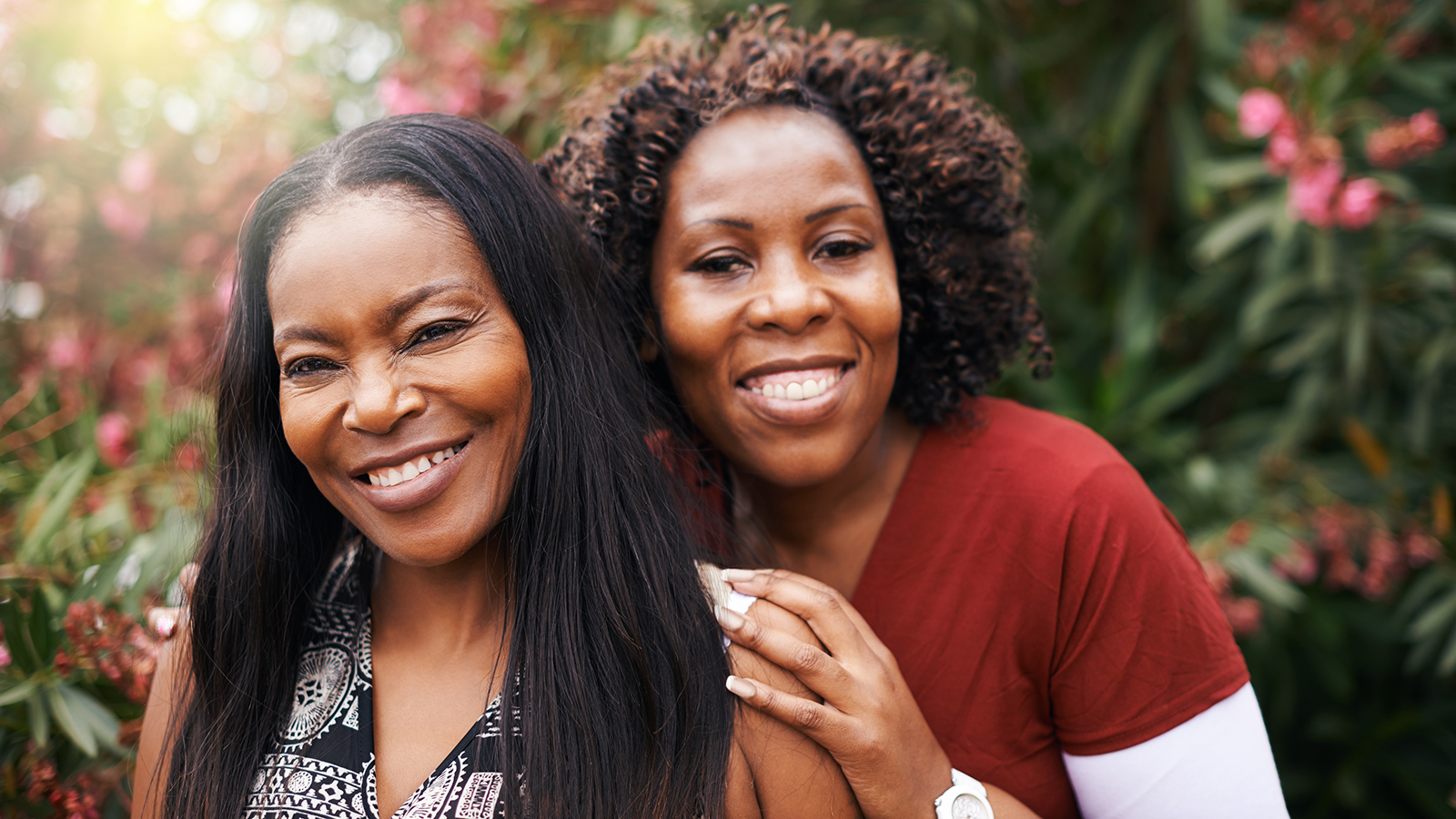 Two women smiling in a garden