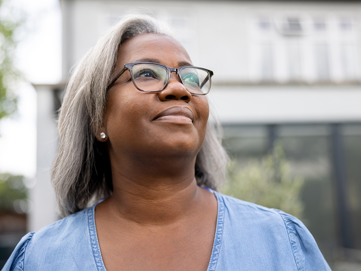 Middle aged African American woman looking into the distance and smiling
