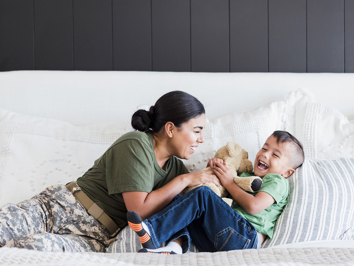Female woman in the military plays with her young son