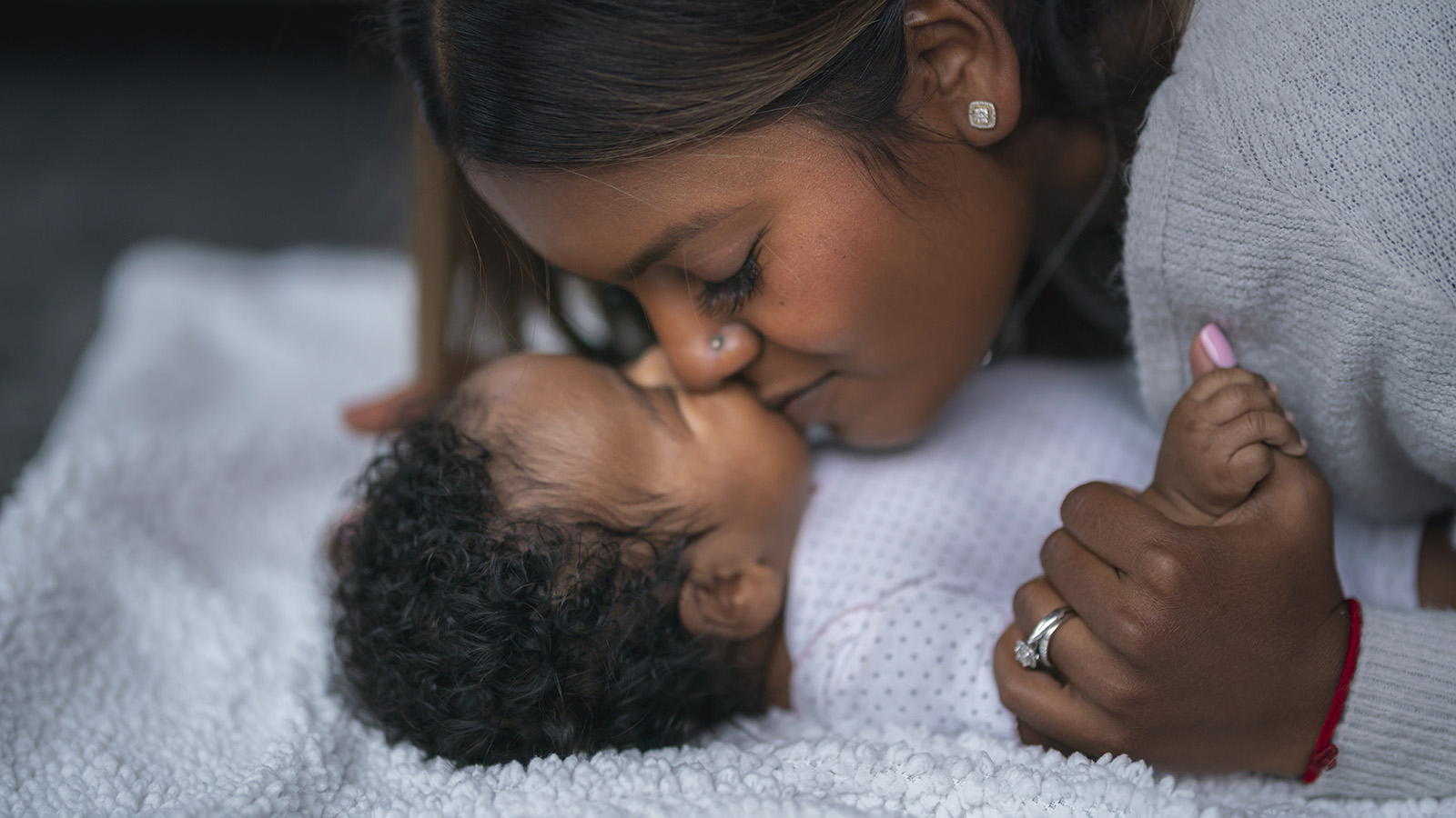 Women kissing sleeping baby